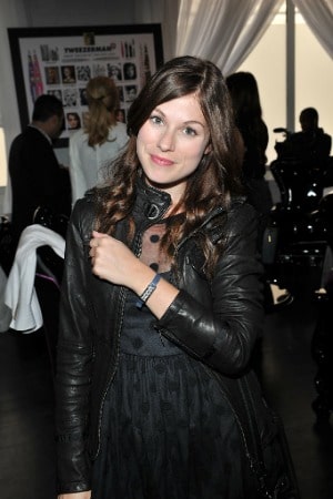 Meghan Heffern wearing black clothes and wrist band on the set of a film shoot